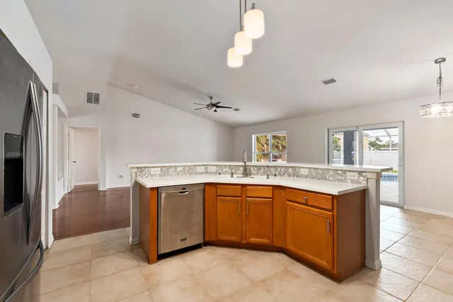 a view of a kitchen with stainless steel appliances granite countertop a stove and a sink