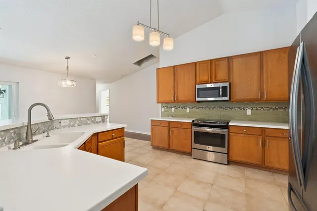 a kitchen with stainless steel appliances granite countertop a sink a stove top oven a granite counter space and cabinets