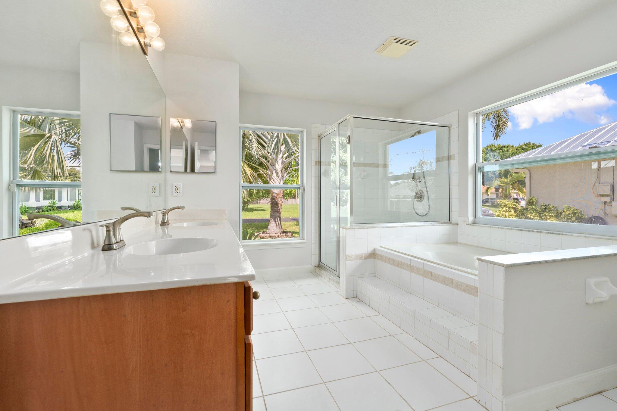 1901 Southwest Diamond Street Port St. Lucie, FL 34953 - Photo 26 of 42 a spacious bathroom with stainless steel appliances granite countertop a sink a bathtub a mirror and next to a window