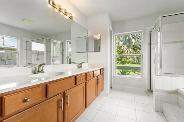 a spacious bathroom with a granite countertop sink mirror and a bathtub