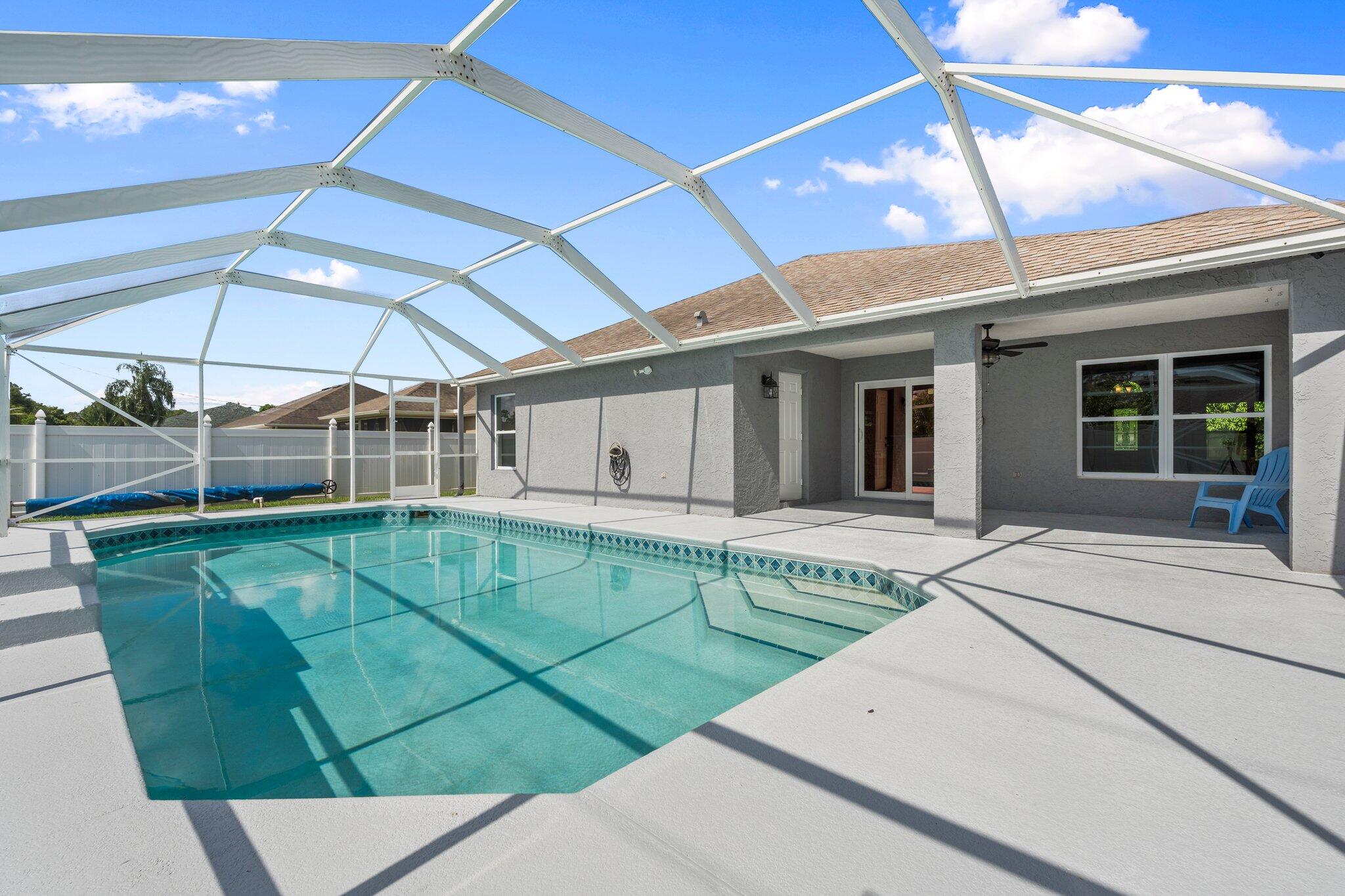 1901 Southwest Diamond Street Port St. Lucie, FL 34953 - Photo 33 of 42 a view of a patio with a table and chairs under an umbrella