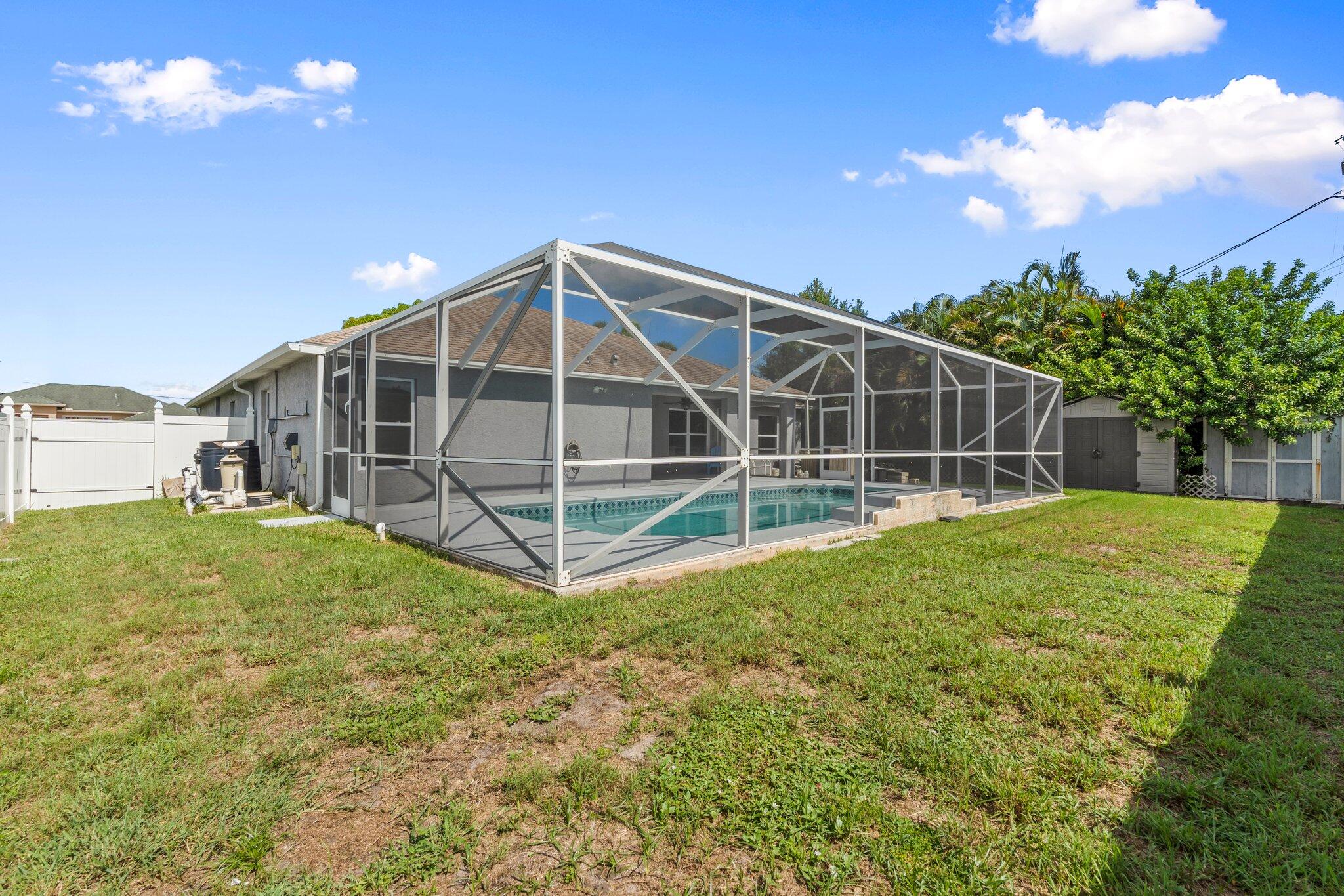 1901 Southwest Diamond Street Port St. Lucie, FL 34953 - Photo 35 of 42 a view of a house with a backyard and a garden