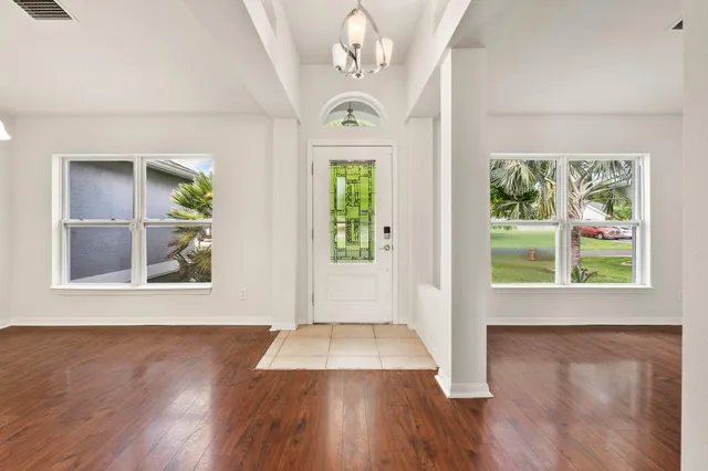 a view of an entryway with wooden floor door and a window