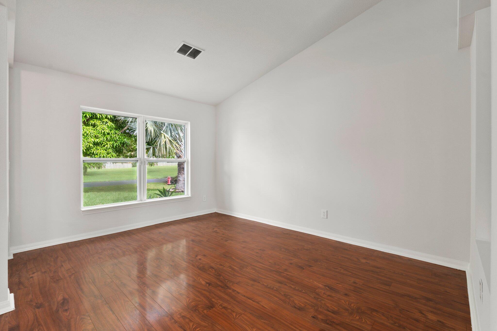 1901 Southwest Diamond Street Port St. Lucie, FL 34953 - Photo 5 of 42 a view of an empty room with wooden floor and a window