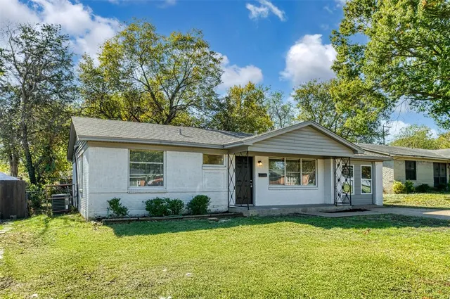 a front view of a house with yard and green space