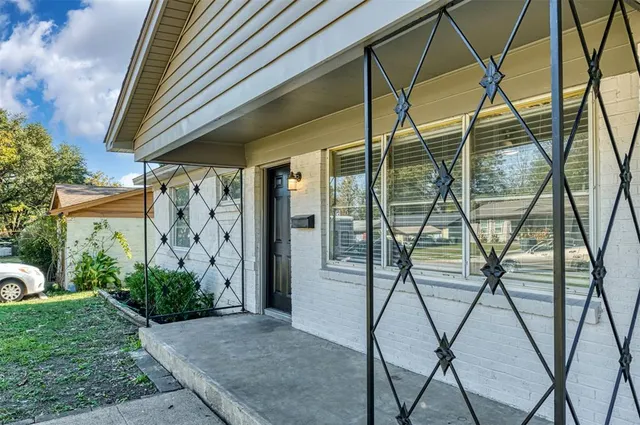 a living room with furniture a rug potted plant and a window