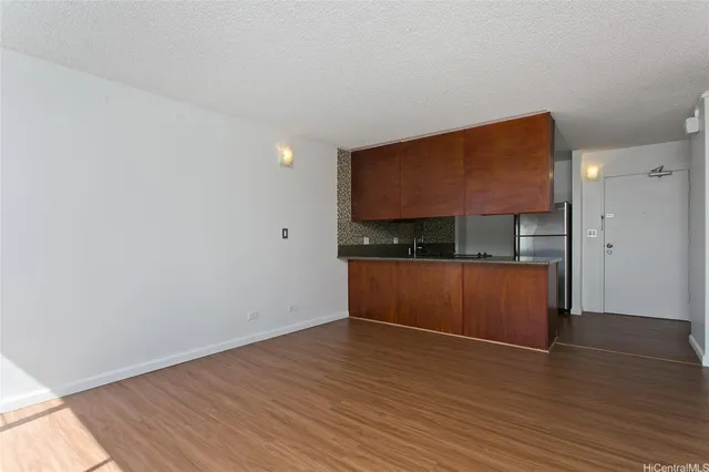 a view of kitchen with refrigerator and wooden floor