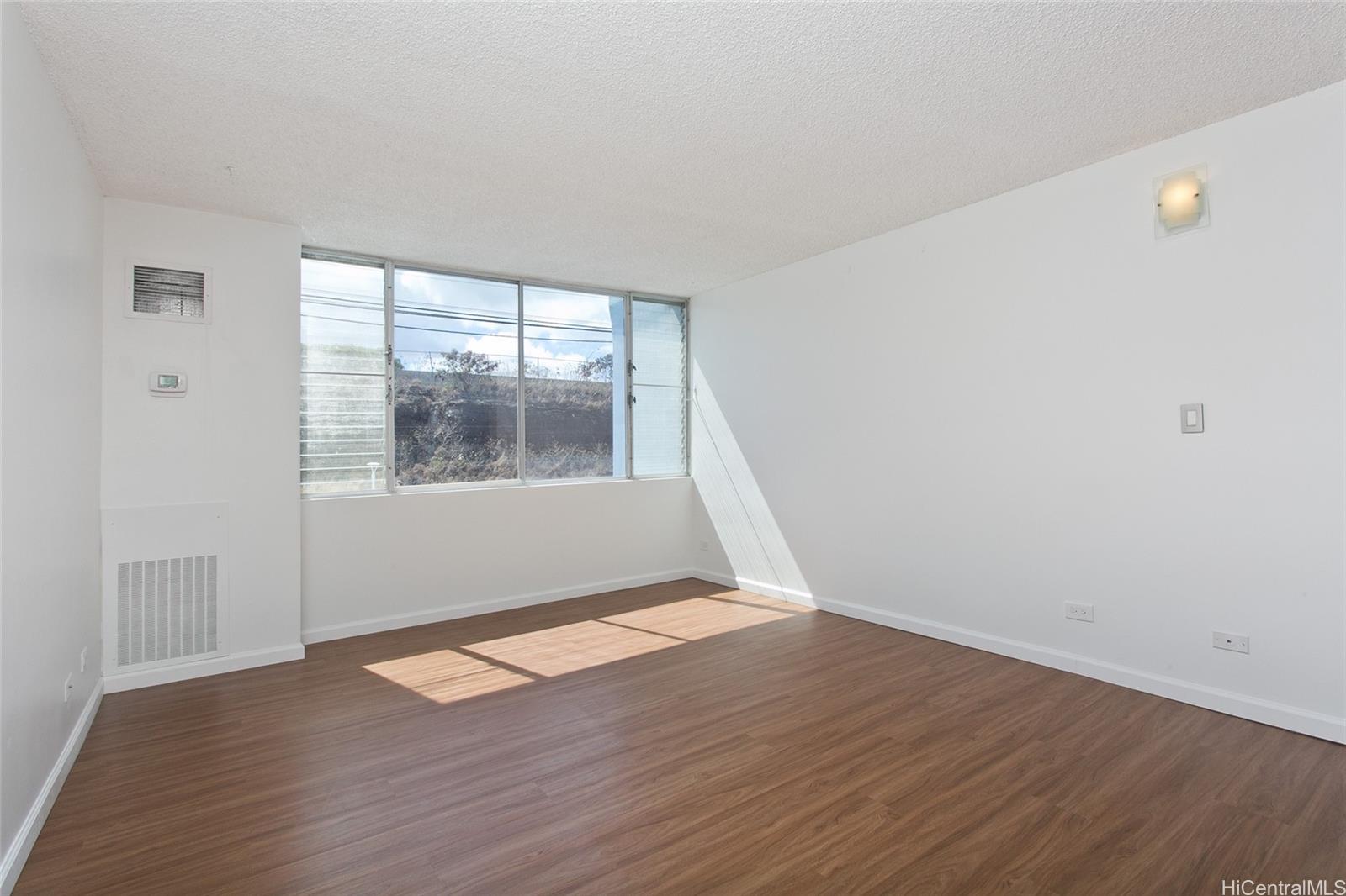3045 Ala Napuaa Place, Unit 306 Honolulu, HI 96818 - Photo 2 of 15 an empty room with wooden floor and windows