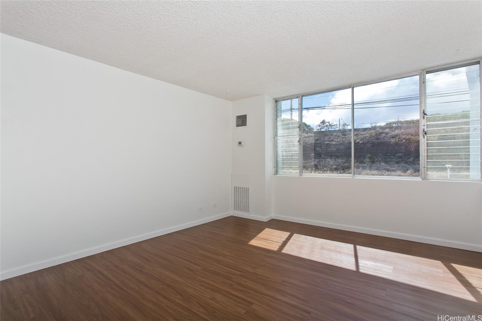 3045 Ala Napuaa Place, Unit 306 Honolulu, HI 96818 - Photo 3 of 15 wooden floor in an empty room with a window