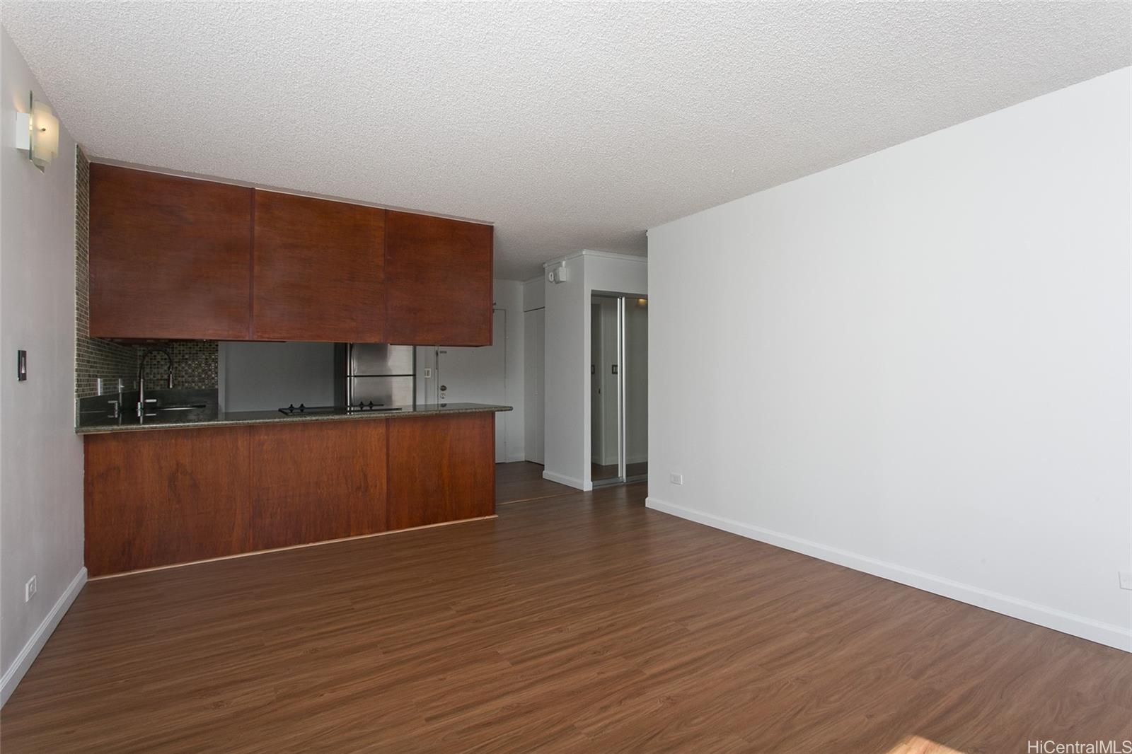 3045 Ala Napuaa Place, Unit 306 Honolulu, HI 96818 - Photo 4 of 15 a view of empty room with wooden floor and cabinets