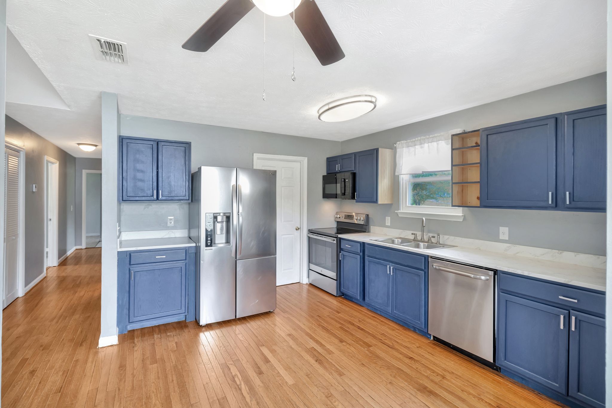 7543 Chadwick Drive Murfreesboro, TN 37129 - Photo 7 of 16 a kitchen with stainless steel appliances granite countertop a refrigerator a sink dishwasher a stove with wooden floor and cabinets