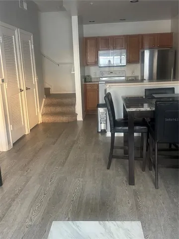 a dining hall with stainless steel appliances granite countertop a refrigerator and cabinets