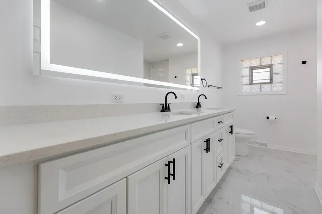 a bathroom with a double vanity sink and a mirror