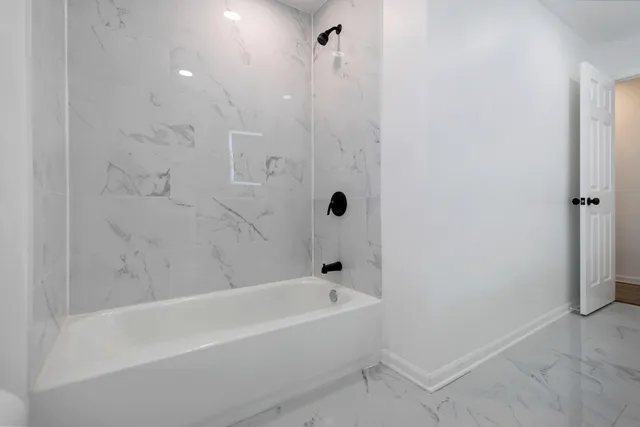 a white bath tub sitting next to a shower