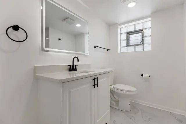a bathroom with a toilet sink and mirror