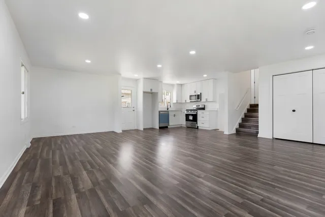 a view of empty room with wooden floor and window