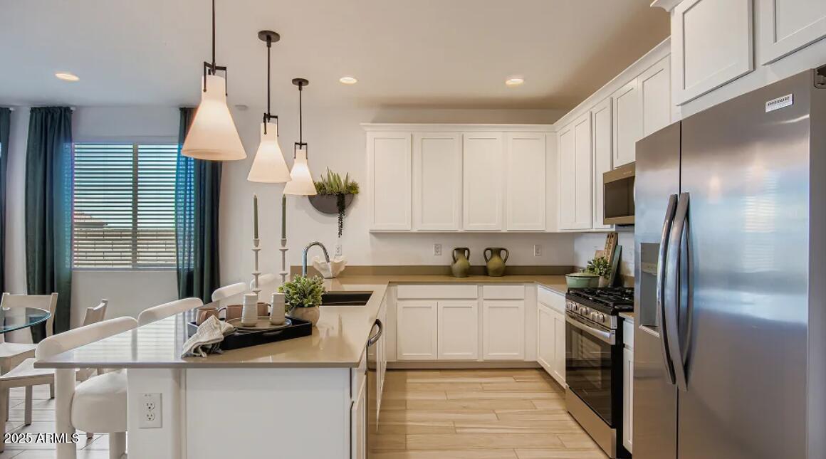 9540 West Flower Street Phoenix, AZ 85392 - Photo 2 of 22 a kitchen with stainless steel appliances granite countertop a sink refrigerator and cabinets