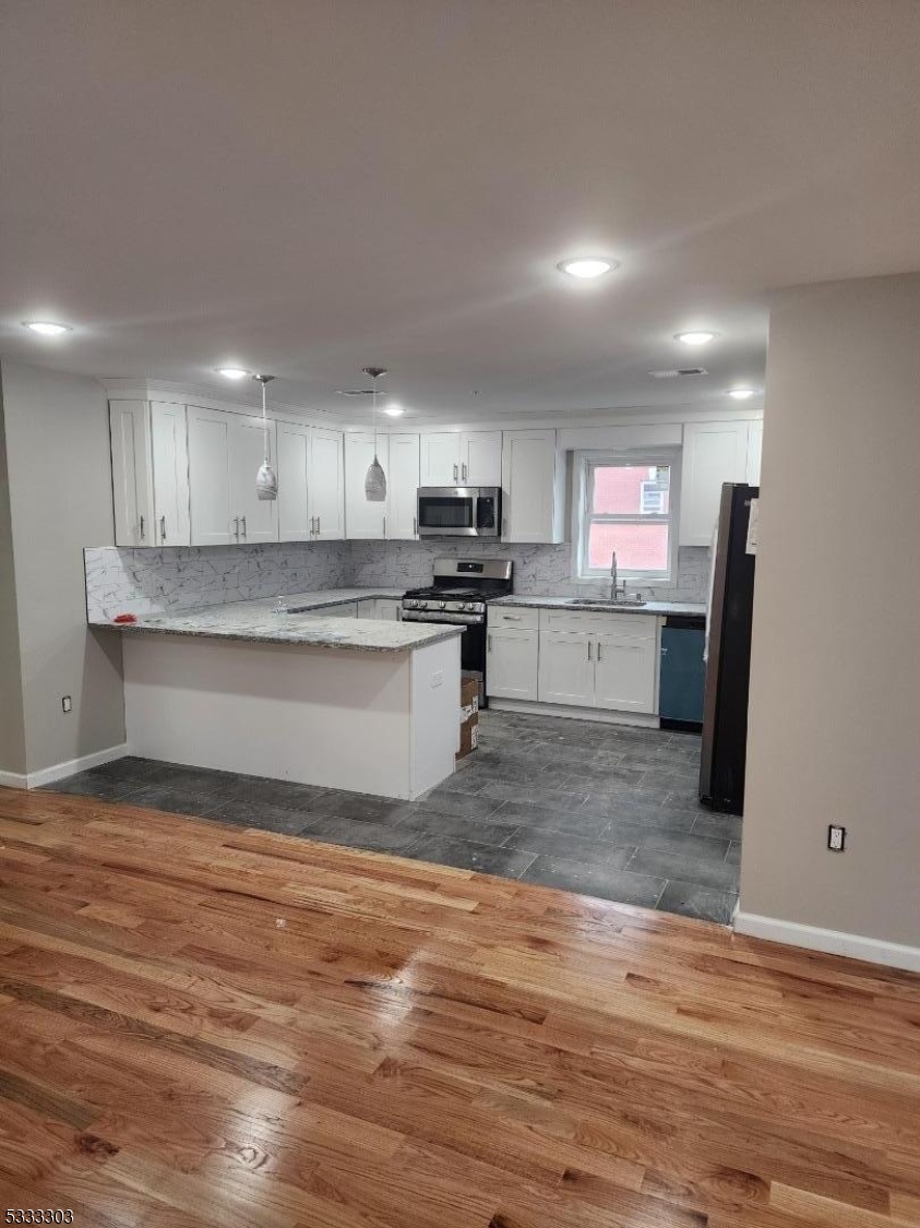 20 Garibaldi Avenue Newark, NJ 07114 - Photo 12 of 12 a kitchen with stainless steel appliances granite countertop a refrigerator sink and cabinets