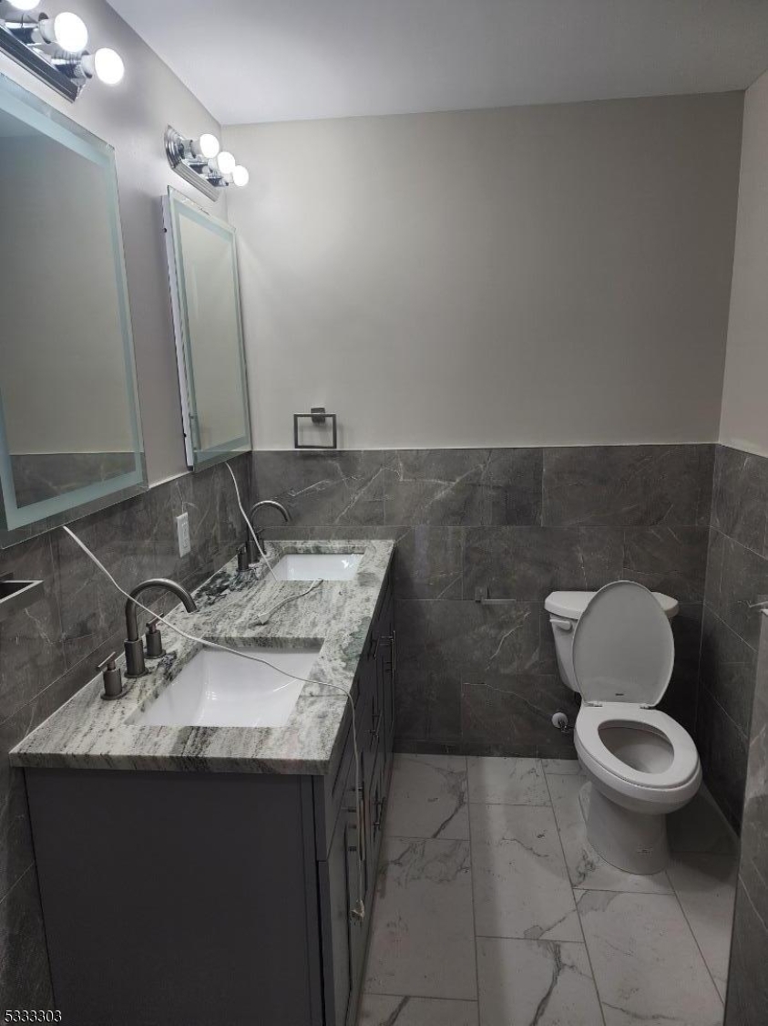 20 Garibaldi Avenue Newark, NJ 07114 - Photo 5 of 12 a bathroom with a granite countertop sink a toilet and a mirror