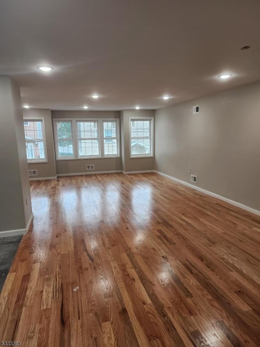 20 Garibaldi Avenue Newark, NJ 07114 - Photo 10 of 12 an empty room with wooden floor and windows