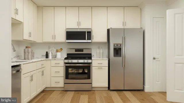 a kitchen with stainless steel appliances white cabinets and a refrigerator