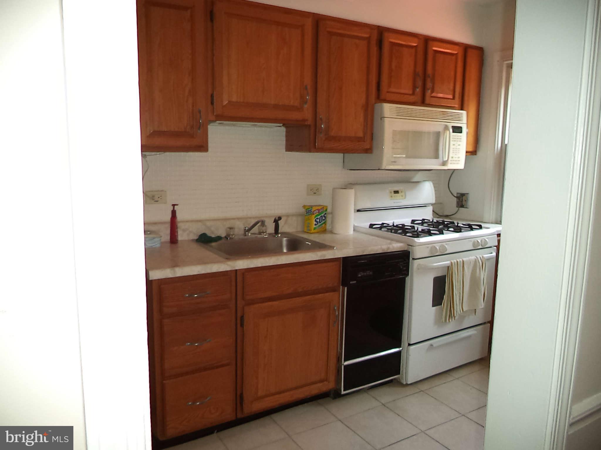 1132 Elm Road Baltimore, MD 21227 - Photo 13 of 27 a kitchen with stainless steel appliances granite countertop a stove and a microwave