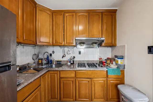 a kitchen with stainless steel appliances granite countertop a sink a stove and cabinets