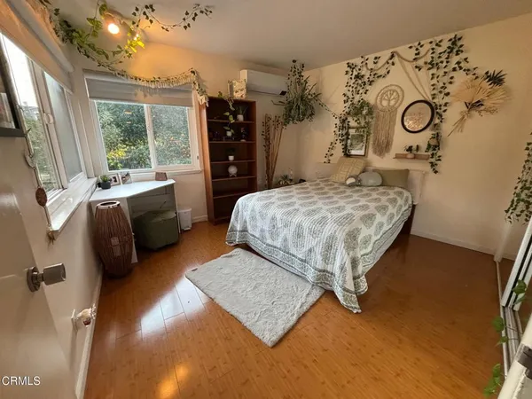 a bedroom with a bed dresser and a window