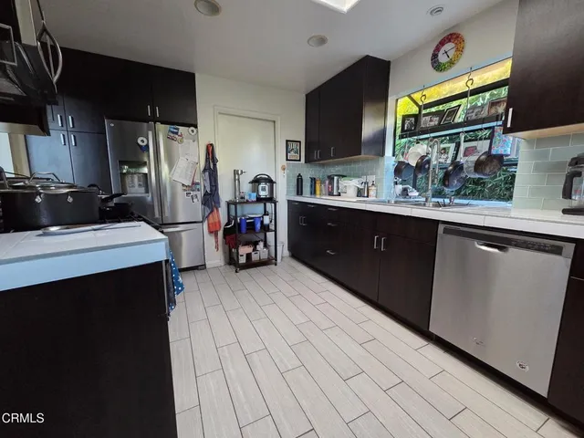 a kitchen with stainless steel appliances a sink and a refrigerator