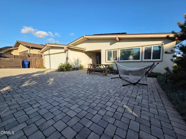 a view of a house with backyard and sitting area