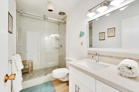 a bathroom with a sink a toilet and shower
