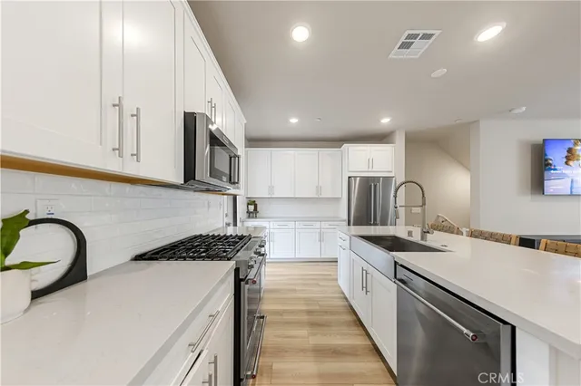 a kitchen with stainless steel appliances granite countertop a sink stove and cabinets