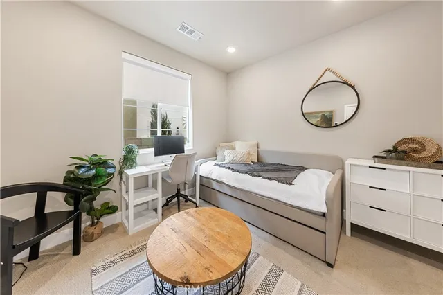 a living room with furniture a window and a potted plant
