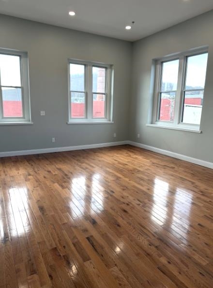 38 Mill Street, Unit 4 Paterson, NJ 07501 - Photo 2 of 6 an empty room with wooden floor and windows