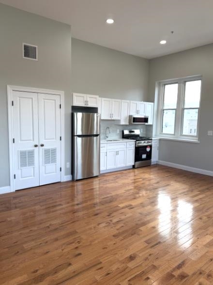 38 Mill Street, Unit 4 Paterson, NJ 07501 - Photo 3 of 6 a view of kitchen with kitchen island a sink wooden floor and stainless steel appliances