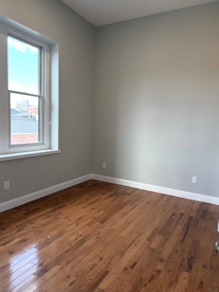 38 Mill Street, Unit 4 Paterson, NJ 07501 - Photo 4 of 6 an empty room with wooden floor and windows