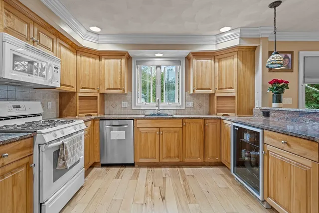 a kitchen with stainless steel appliances granite countertop a stove a sink and a refrigerator