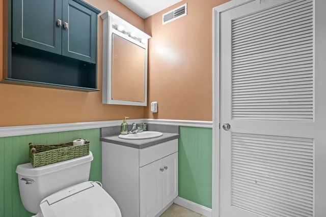 a bathroom with a toilet sink and mirror