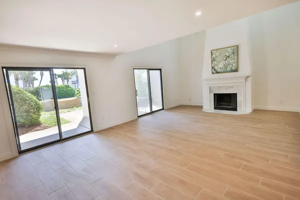 an empty room with windows and fireplace