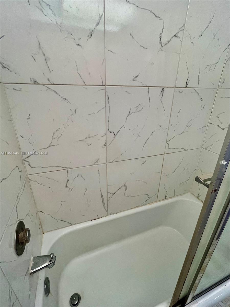 3670 Inverrary Drive, Unit 1K Lauderhill, FL 33319 - Photo 5 of 13 a bathroom with a bathtub