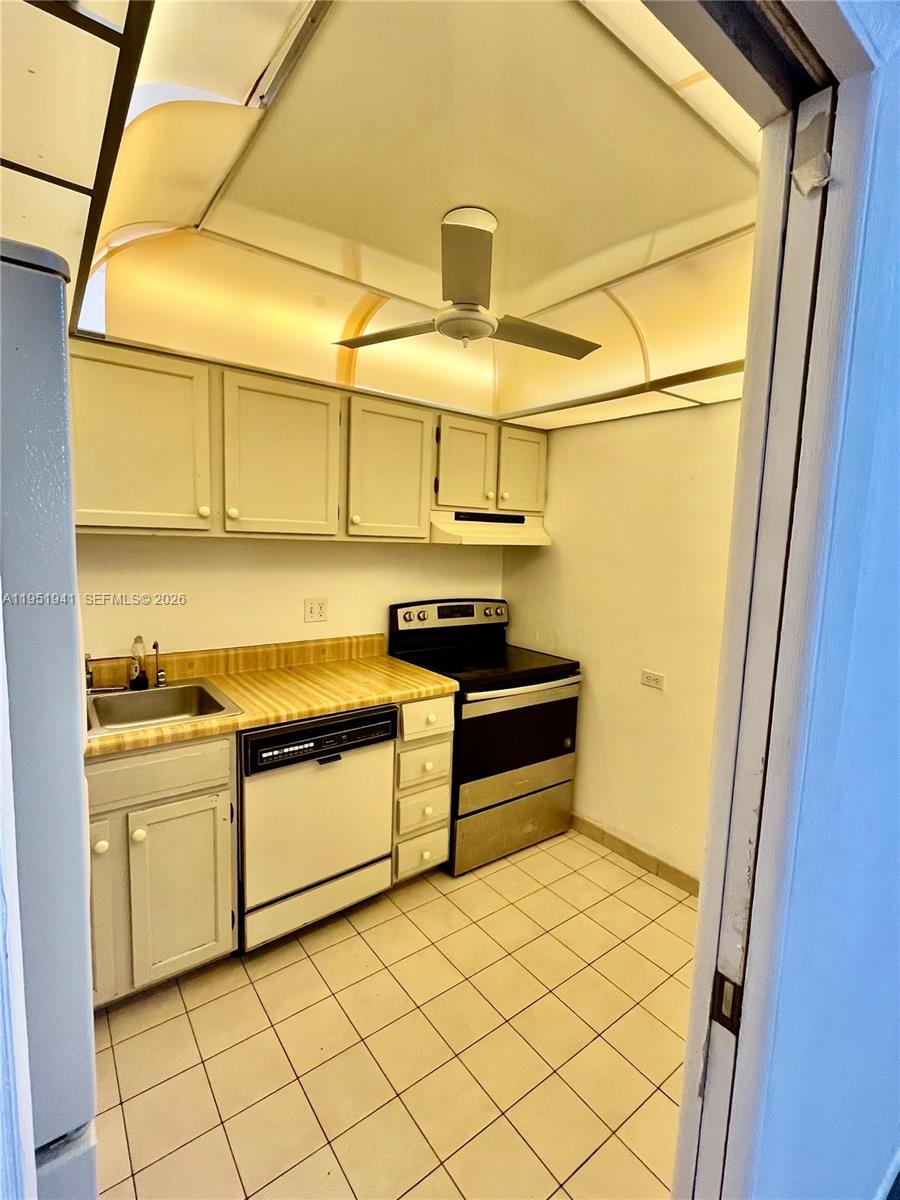 3670 Inverrary Drive, Unit 1K Lauderhill, FL 33319 - Photo 7 of 13 a kitchen with stainless steel appliances a stove refrigerator and cabinets
