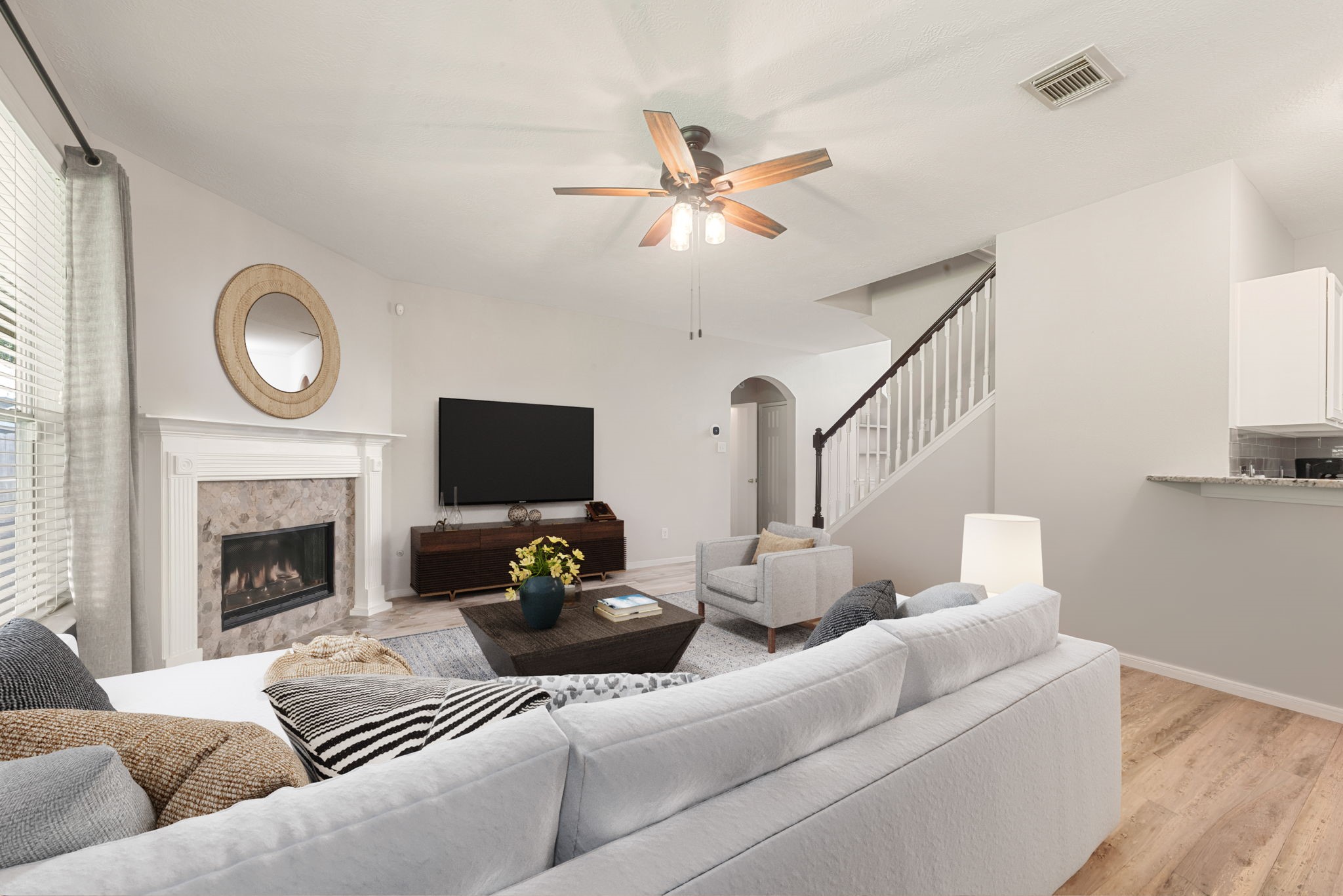 19726 Teller Boulevard Spring, TX 77388 - Photo 5 of 24 High ceilings and a chic dark-stained ceiling fan enhance the airy feel, while the seamless flow into the kitchen makes it an ideal setting for hosting guests or quiet evenings. Whether you're curling up by the fire or enjoying the spacious layout, this room is designed for effortless living.