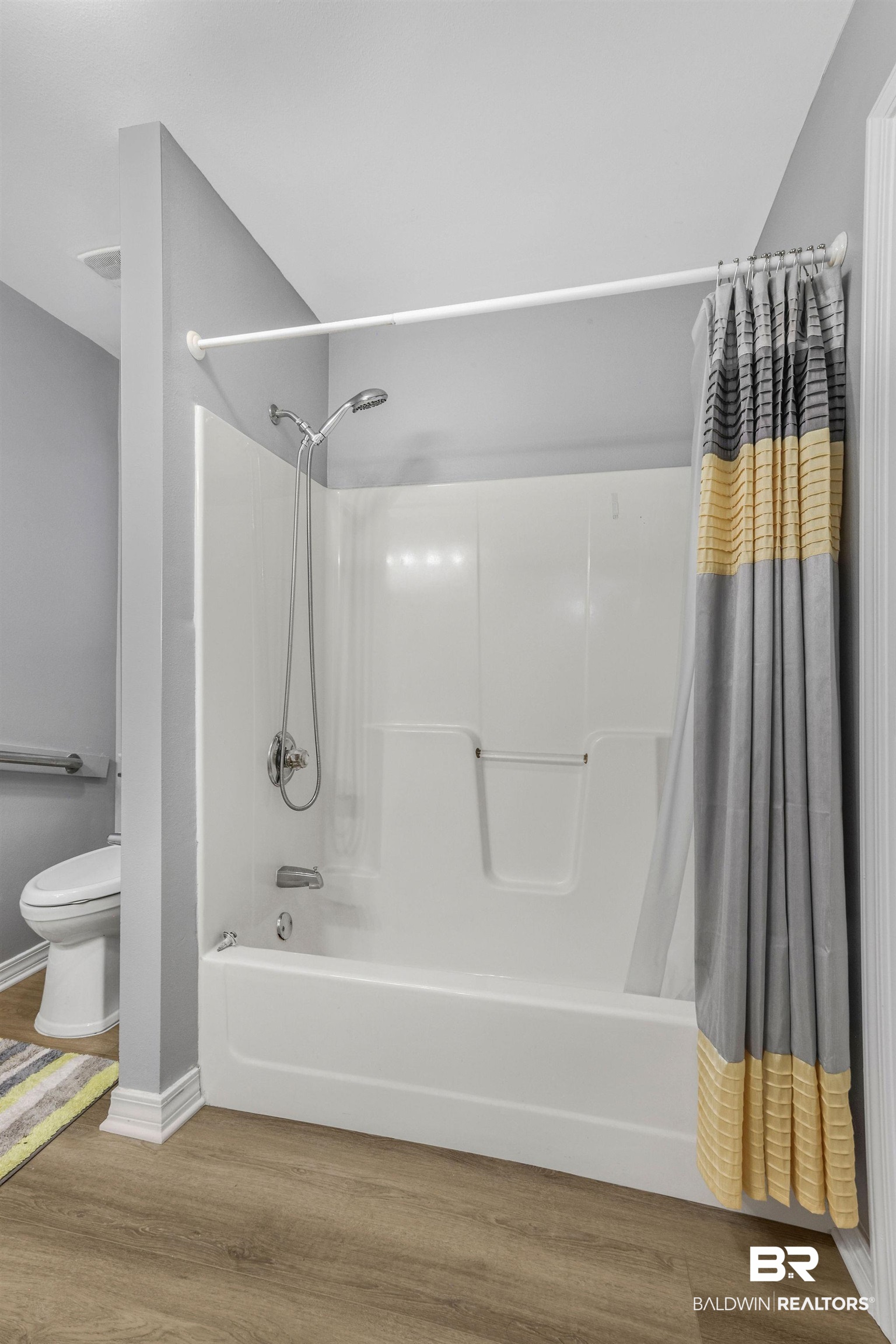 18620 Hammond Street Robertsdale, AL 36567 - Photo 11 of 23 Bathroom featuring toilet, wood-type flooring, and shower / bathtub combination with curtain