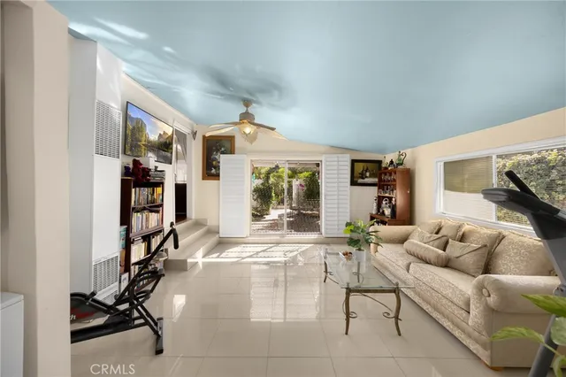 a living room with furniture gym equipment and a large window