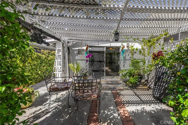 a view of a patio with table and chairs and a large tree