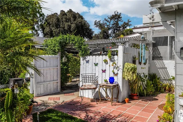 a view of a chair and table in backyard with potted plants