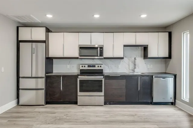 a kitchen with kitchen island granite countertop a stove a sink and a refrigerator