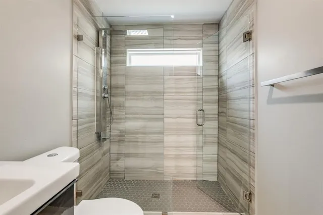 a bathroom with a shower a toilet and a sink