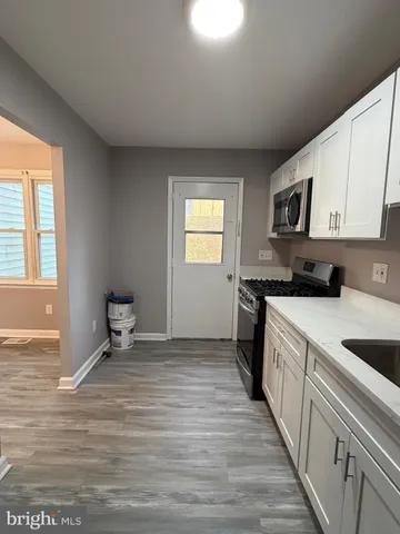 a kitchen with granite countertop a stove a sink and a microwave