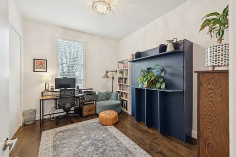 a view of a workspace with furniture and a window